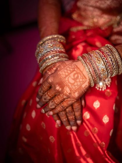 A close-up of the bride's bangles and henna design. These detail shots highlight the beautiful accessories and traditions that complete the bridal ensemble.