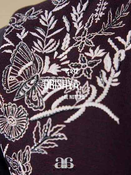 The soul of our work is in the details. This close up view showcases the exquisite silver hand embroidery, featuring a butterfly motif, that adorns our space blue bundi set, reflecting our commitment to meticulous craftsmanship.