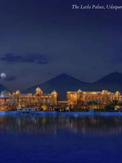 The Leela Palace, Udaipur, shimmering on the lake at night. A venue that is the very definition of royal splendor and a dream destination for a palace wedding.