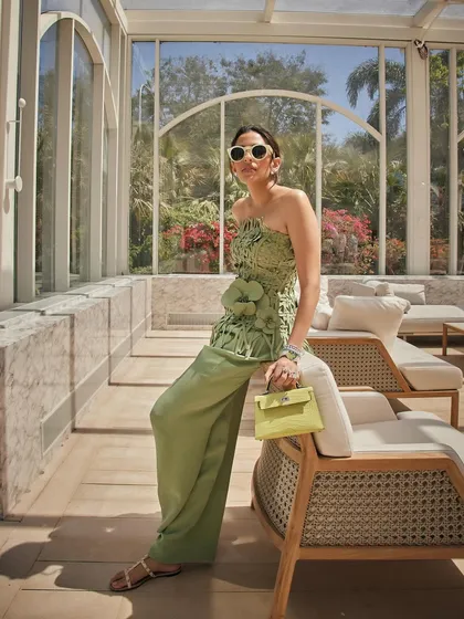A full look at the Oscar de la Renta ensemble, featuring a woven bustier and matching wide-leg pants in a beautiful shade of green. This is high-fashion resort wear.