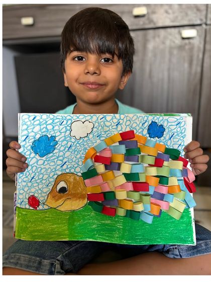 A student shows off his colourful turtle craft, which uses a fun paper weaving technique to create the shell. We are always exploring new and creative craft ideas.