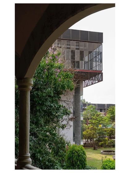 A view of the cantilevered end of "Hoverspace," framed by an archway of an older campus building. This juxtaposition highlights the dialogue between different architectural eras.