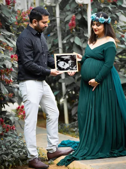 A sweet announcement in a beautiful garden. This couple holds up their baby's ultrasound picture, sharing their exciting news in a natural and lovely setting.