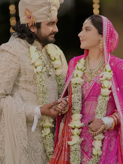 A classic wedding portrait of the couple looking at each other, their white rose varmalas adding to the elegance of the moment.