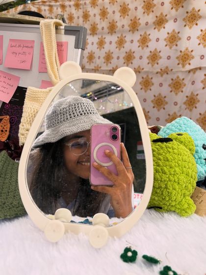 A mirror selfie of me wearing one of my handmade crochet bucket hats. This grey hat is lightweight and breathable, making it a perfect accessory for a sunny day out.