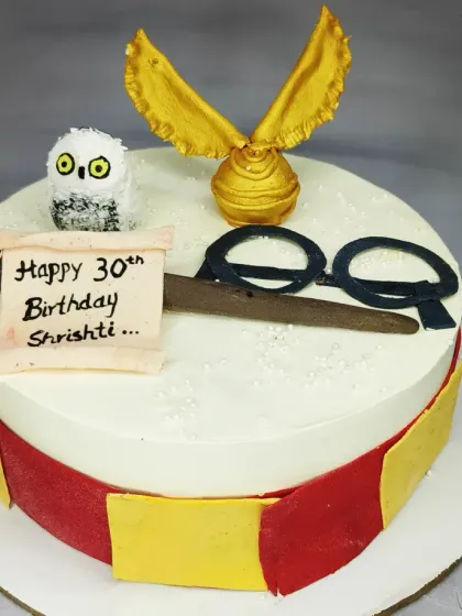 A minimalist Harry Potter cake with a French vanilla flavor. This design features the iconic glasses, scarf, and a cute fondant owl.