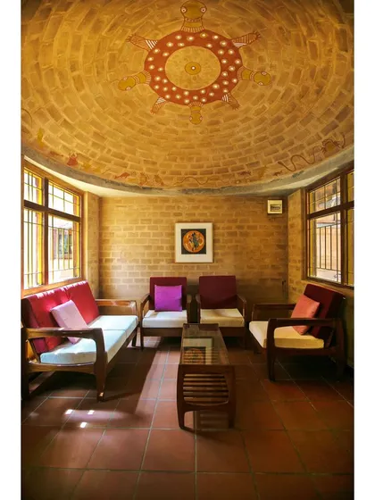 The domed meditation room in the Professor's Residence, featuring a beautiful mural on the ceiling. The space is constructed with earth blocks, creating a serene and thermally comfortable environment for yoga and reflection.
