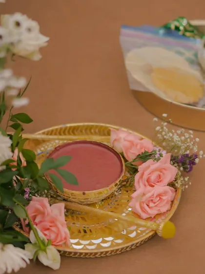 The details of a Haldi ceremony tray, with a bowl of paste and fresh pink roses. I believe even the smallest elements should be beautifully presented to enhance the overall experience.