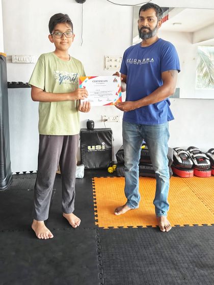 This young man receives his certificate, a symbol of his commitment and the new skills he learned during our two-month kids' Jiu-Jitsu and MMA camp.