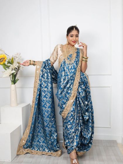 This royal blue brocade Nauvari with a golden border is a statement piece, ideal for weddings and grand receptions.