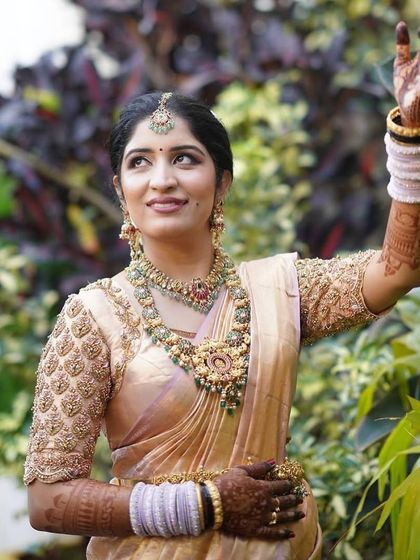A graceful pose showing off her full-sleeve mehendi and traditional white bangles.