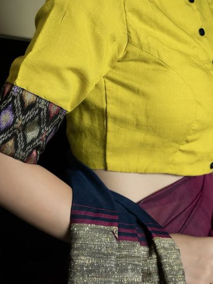 Sunshine stitched into style. Our yellow cotton boat neck blouse with a front button detail and contrasting printed sleeve cuffs is a simple yet elegant choice for the season.