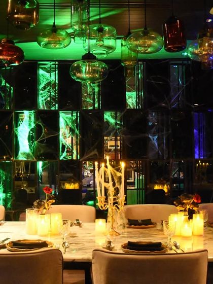 Even the dining area was part of the theme. This Halloween dinner table is set with elegant candelabras and surrounded by moody green and blue lighting, creating a sophisticated yet spooky dining experience.