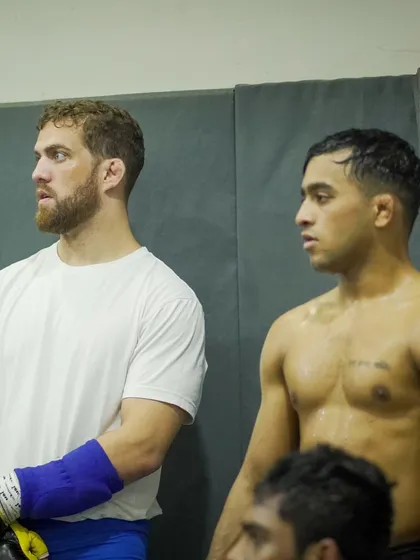 Two of our pro fighters watch a sparring round. The team environment means everyone is learning, even when they're on the sidelines. Iron sharpens iron.