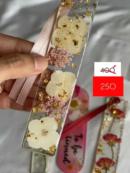This white floral mini bookmark with gold flakes is another unique piece from the sale.