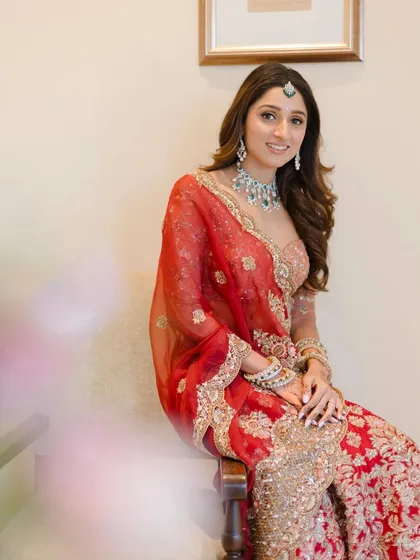 A moment of calm before the celebration. I styled this portrait of the bride in her red Shyamal Bhumika lehenga, using the soft, diffused light to create a gentle and elegant image.