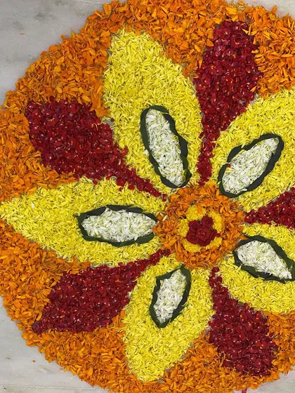 A close-up of the intricate patterns and vibrant colors of our Onam pookalam, made entirely of fresh flower petals.