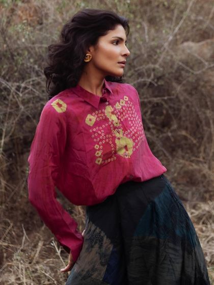 Another shot from an outdoor editorial, featuring a tie-dye silk set. The movement in the pose highlights the fluidity of the fabric, while the earthy tones of the outfit connect beautifully with the natural surroundings.