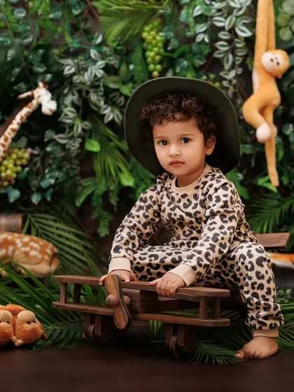 A little adventurer with his wooden airplane, ready to take off on a jungle expedition.