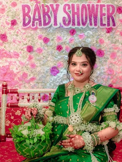The complete look for a baby shower, with the mom-to-be seated on a decorated swing. She is wearing my custom green and white floral jewellery and holding a matching green floral basket.