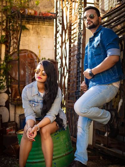 A stylish couple poses in a rustic, industrial setting, both wearing denim. We can match the location and style of the shoot to your personal aesthetic, from romantic to edgy.