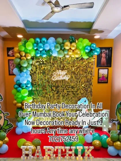 A roaring dinosaur-themed birthday party for Harthik. This setup includes a green and blue balloon arch, large T-Rex cutouts, and marquee letters spelling out the birthday boy's name.