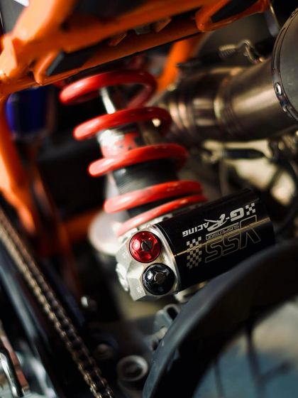 This YSS G-Racing suspension unit, with its preload and rebound adjustment, is being fitted to a KTM to improve its ride quality.