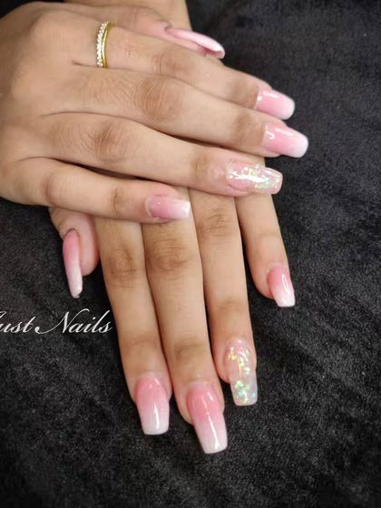 A pretty pink and white ombre set on long, square-shaped nails, with a beautiful encapsulated glitter accent nail.
