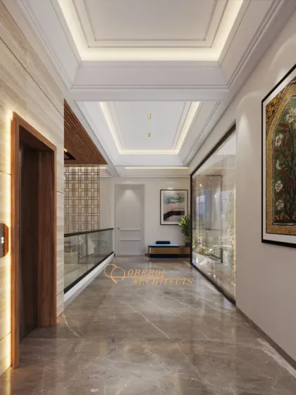 A bright and luxurious hallway next to an elevator, featuring coffered ceilings, marble floors, and a glass partition that offers a view into a living space.
