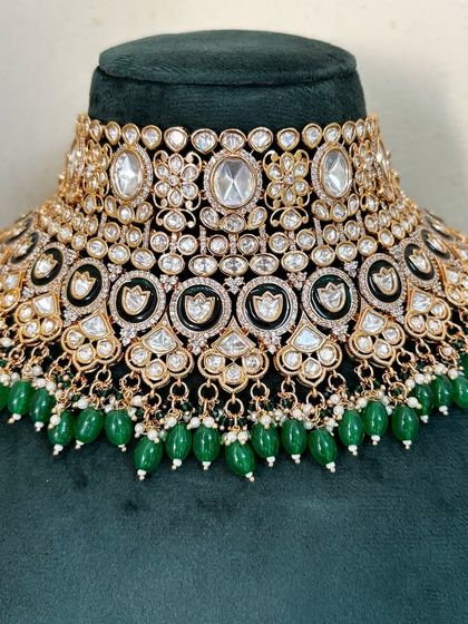 An elaborate bridal choker with multiple layers of Kundan stones and green bead drops. This rental piece offers a very grand and full look.