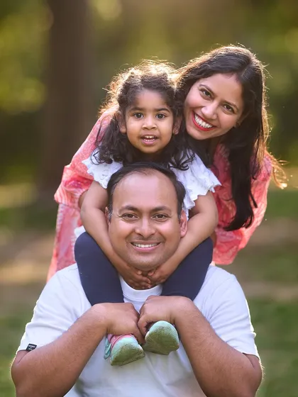 A classic family portrait with a playful twist. Getting kids up on their parents' shoulders is a great way to create a dynamic composition and bring out natural smiles from everyone for a perfect family photo.