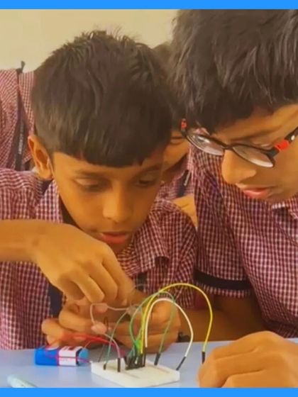 Two students lean in close, their attention fully on the circuit they are building. This shot highlights the intense focus and teamwork that goes into every project.