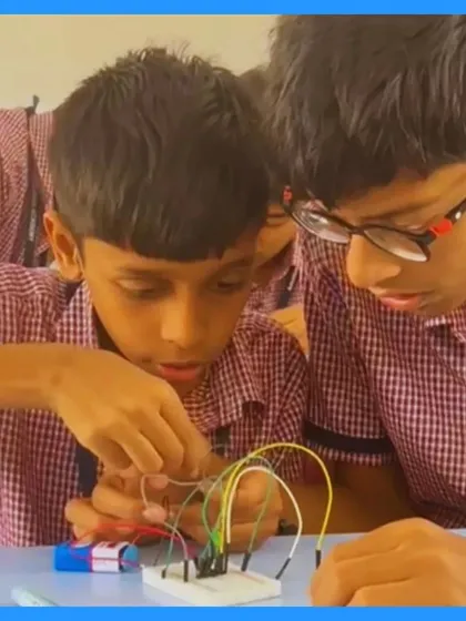 A close-up shot of students carefully connecting jumper wires on a breadboard. This image highlights the focus and precision required in building circuits, a fundamental skill we teach in our hands-on sessions.