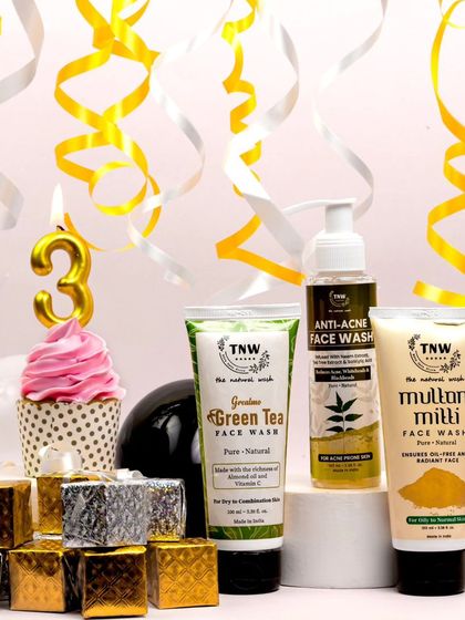 This celebratory shot uses yellow and white streamers to create a sense of fun and movement. The products are arranged on risers, giving them prominence within the festive scene.