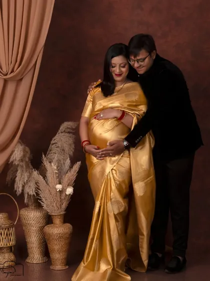 A classic and loving pose, with his hands gently wrapped around her and the baby bump.