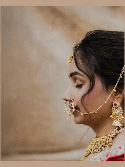 A serene profile shot of the bride, her eyes closed in a moment of quiet contemplation. This close-up beautifully captures the intricate details of her nose ring and jewelry.