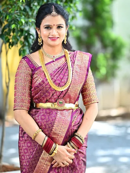 A close-up portrait of the client in her magenta saree, showing the beautiful smile and the intricate work on her custom blouse.