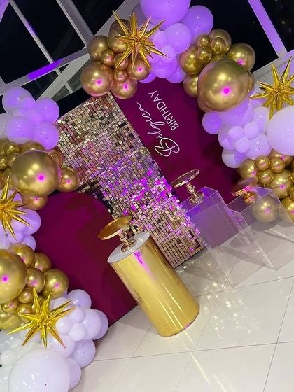 The purple lighting gives this gold and white birthday setup a completely different, club-like vibe.