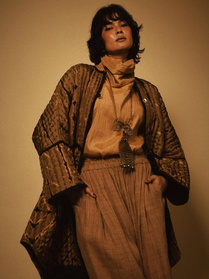 A strong, confident pose in a beautifully crafted quilted jacket. This shot highlights the structure and detail of the garment, showcasing its versatility as a statement piece.