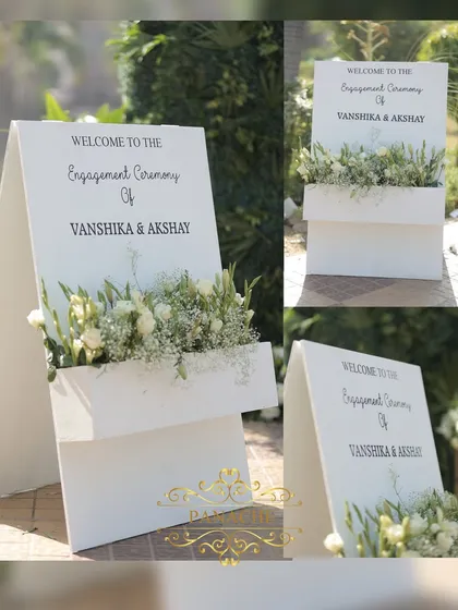 A modern and chic welcome sign for the engagement, with an integrated planter box filled with white flowers.