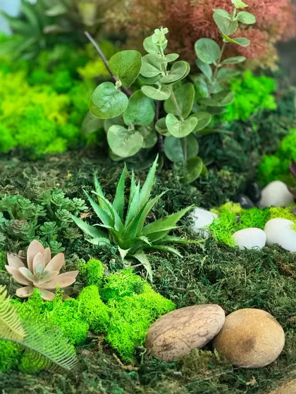 Another detail shot of the terrarium table, showing the careful placement of different mosses, succulents, and decorative stones to create a realistic and beautiful scene.