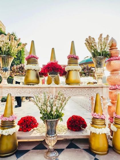 A stunning console setup with traditional Indian temple-inspired decor elements in gold and terracotta, adorned with fresh flowers.