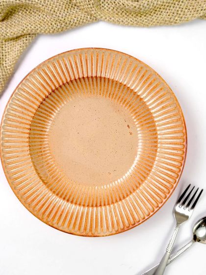 A minimalist flatlay of the ceramic pasta bowl, with the focus entirely on its beautiful ribbed texture. The simple arrangement with a fork and spoon emphasizes its elegance and craftsmanship.