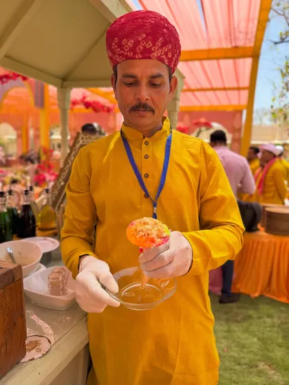 Our staff, dressed in traditional attire, serving a freshly made ice gola. We pay attention to every detail, including the uniforms, to match the event's theme.
