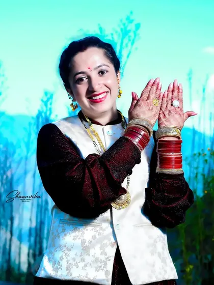 A joyful bride in traditional Himachali wedding attire, showing her beautiful henna-adorned hands. Capturing genuine smiles is a key part of my bridal photography style.