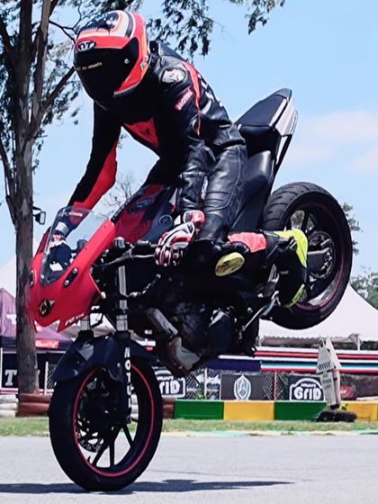 While we focus on racing, we appreciate all forms of skill. A rider performs a wheelie, showcasing incredible bike control on our track during a stunt session.