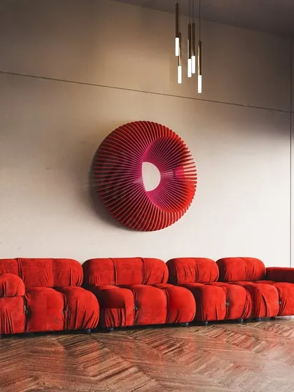 Make a bold statement with our Radiant Circles abstract wall sculpture. The vibrant red and hypnotic, wavy form create a powerful centerpiece, perfect for adding a dramatic and modern flair above a sofa or in an entryway.