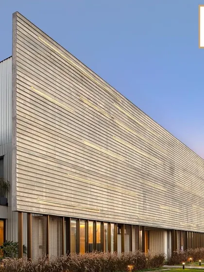 The facade of the award-winning Laxcon Steel Plant Office showcases a textured, brutalist-inspired concrete form. This project is a testament to our philosophy of creating powerful architectural statements for industrial clients that are both functional and visually compelling.