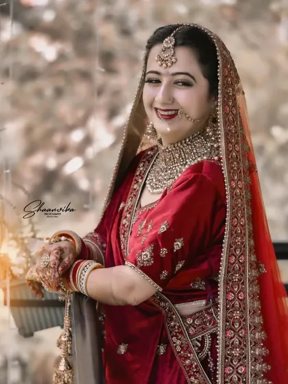 A happy bride leaning against a railing, with a soft, natural background. This relaxed pose creates a beautiful and approachable bridal portrait.