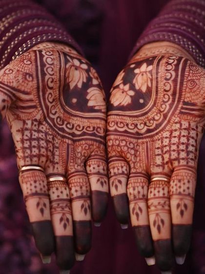 A gorgeous shot of the final stain. The deep, dark color on the fingertips and the rich brown on the palms are signs of high-quality, pure henna.